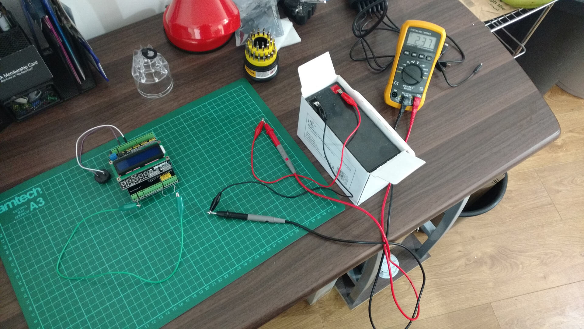 The battery monitor: an Arduino with an LCD shield wired to the battery, with a multimeter checking its voltage