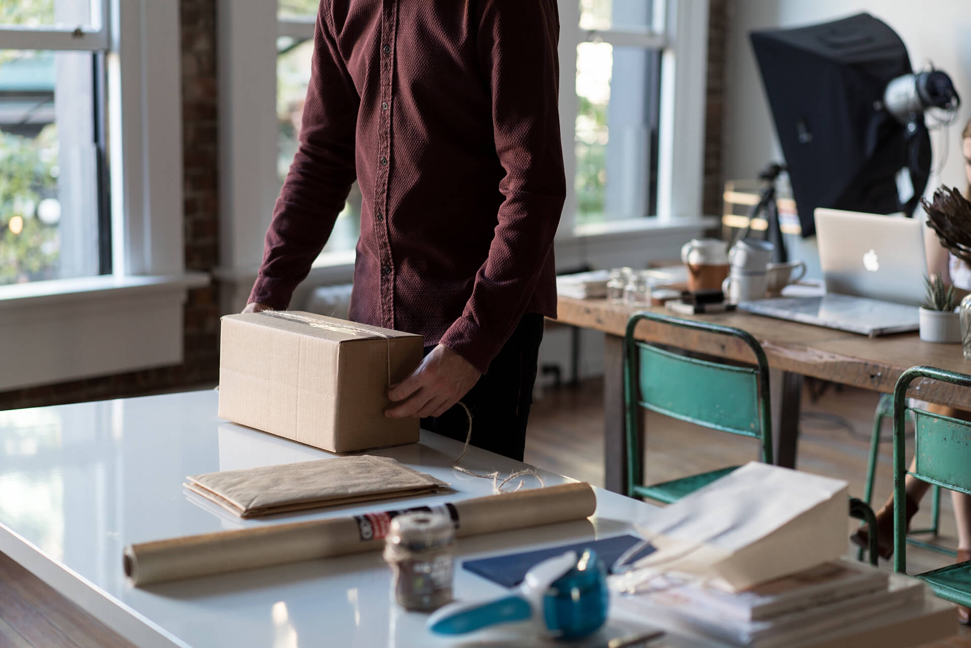 Someone packing a cardboard box at a desk