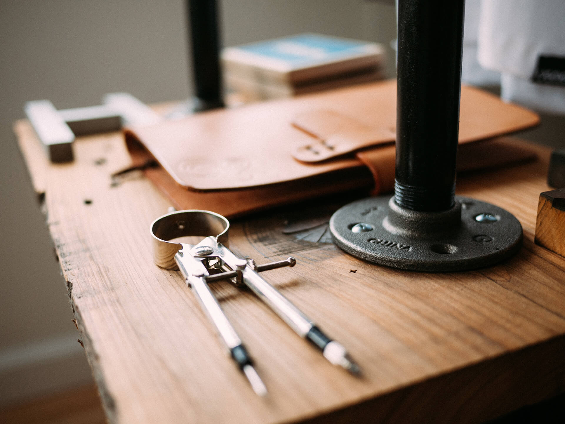 A pair of compasses on a wooden workbench