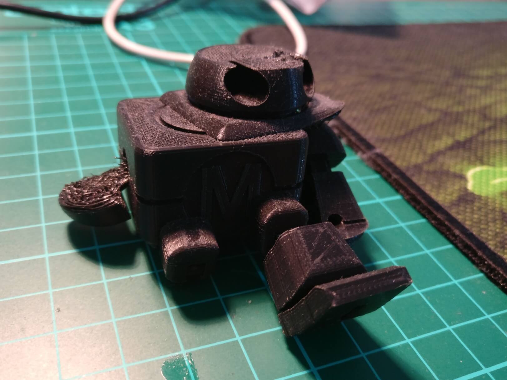The failed 3D print of the Make robot, with misshapen arms and legs