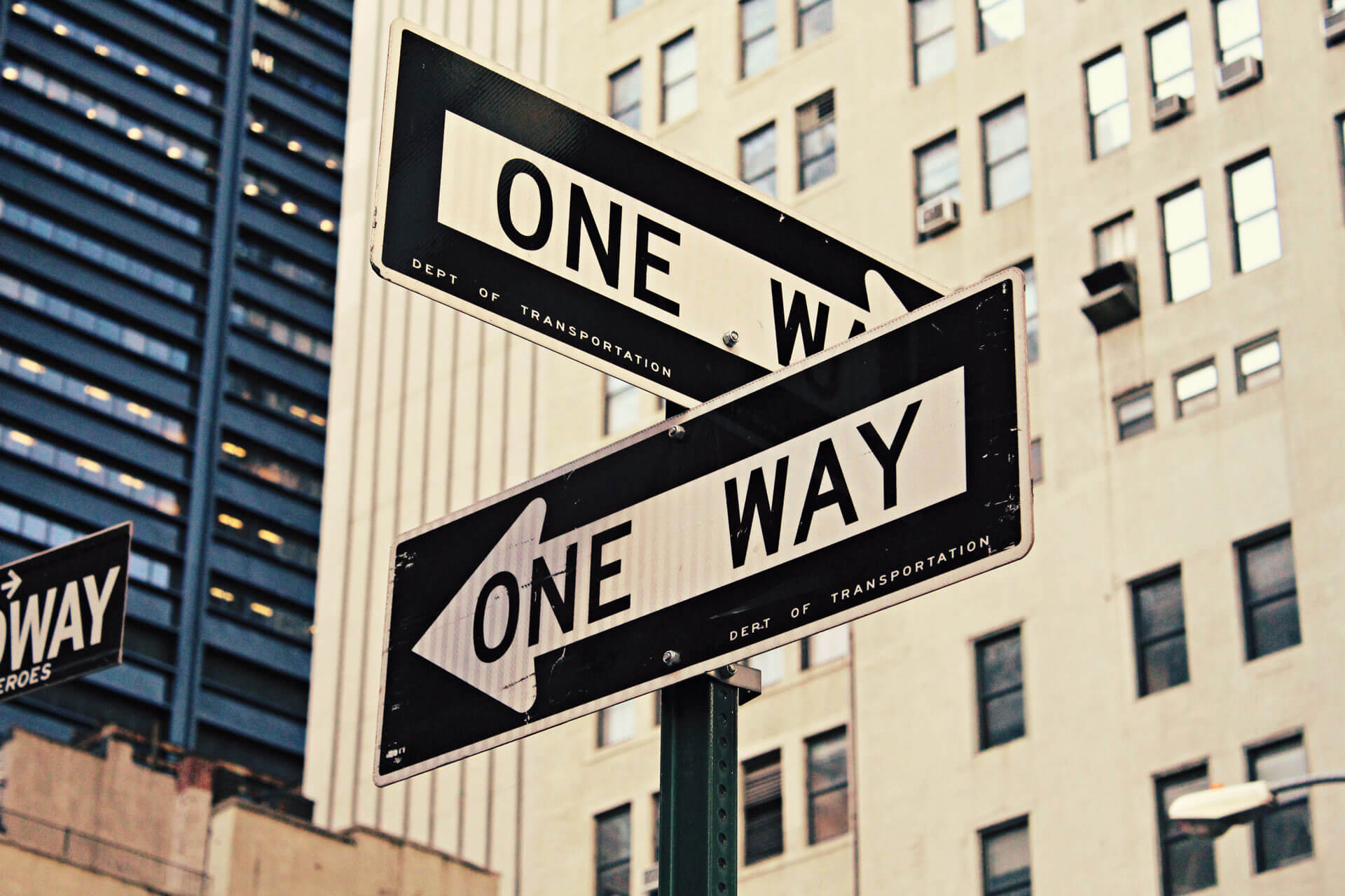 Two One Way street signs pointing in opposite directions