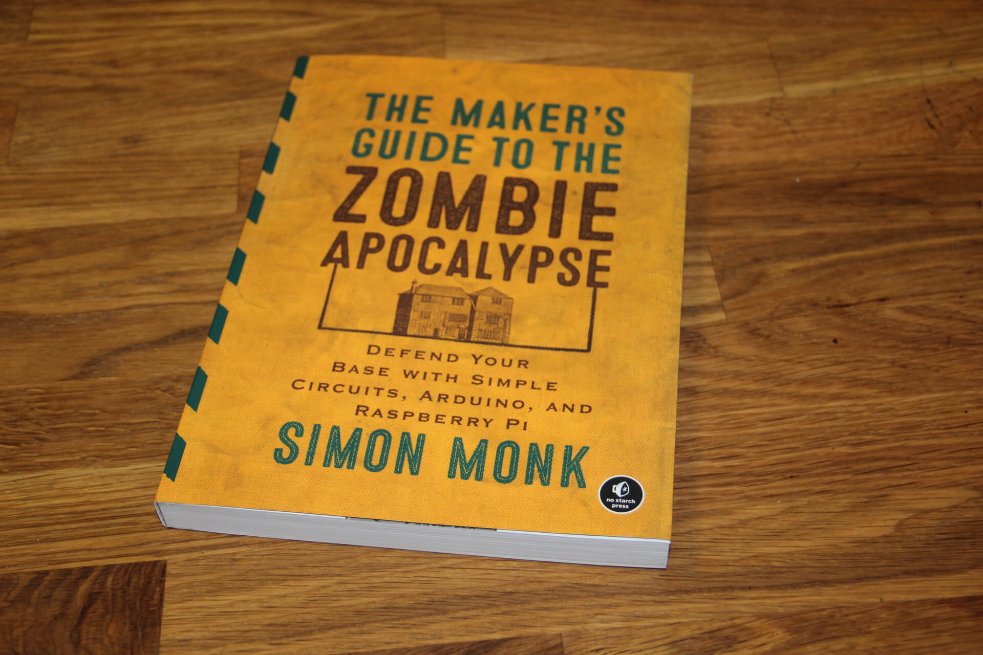 A copy of The Maker's Guide to the Zombie Apocalypse by Simon Monk on a wooden table