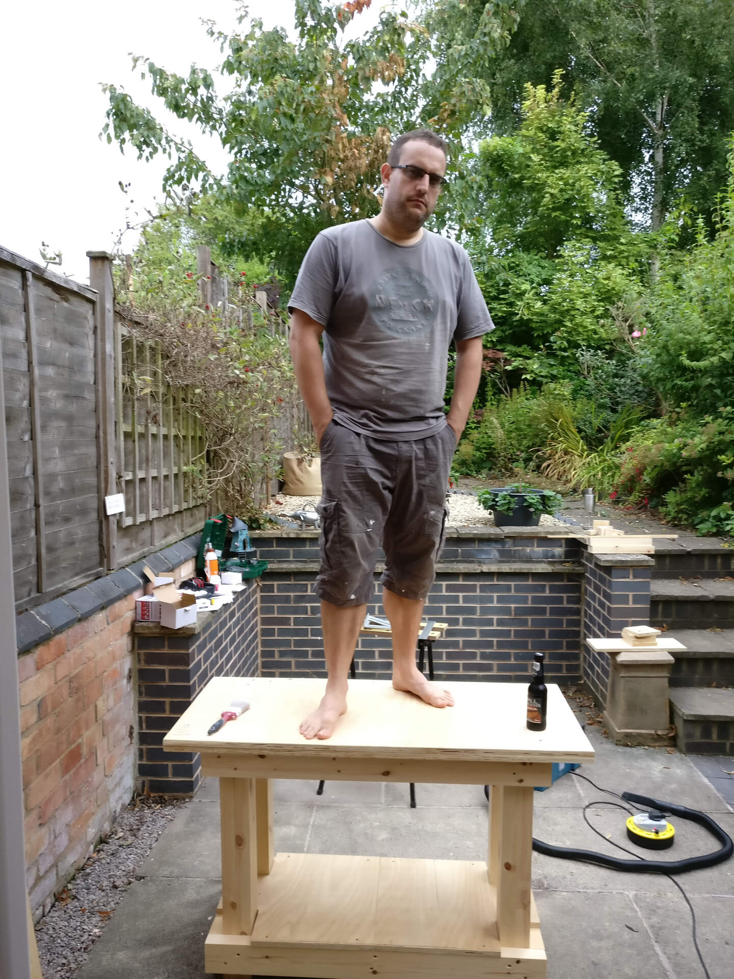 Me standing on the finished workbench to show how sturdy it is