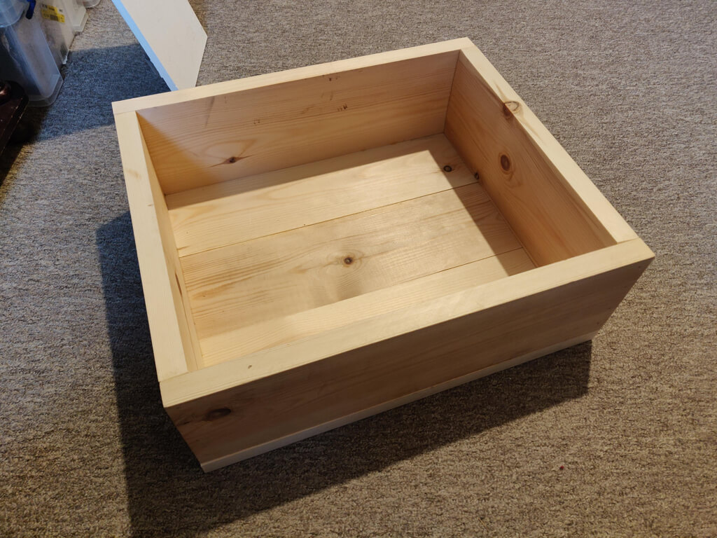 A simple open pine box made from flooring planks