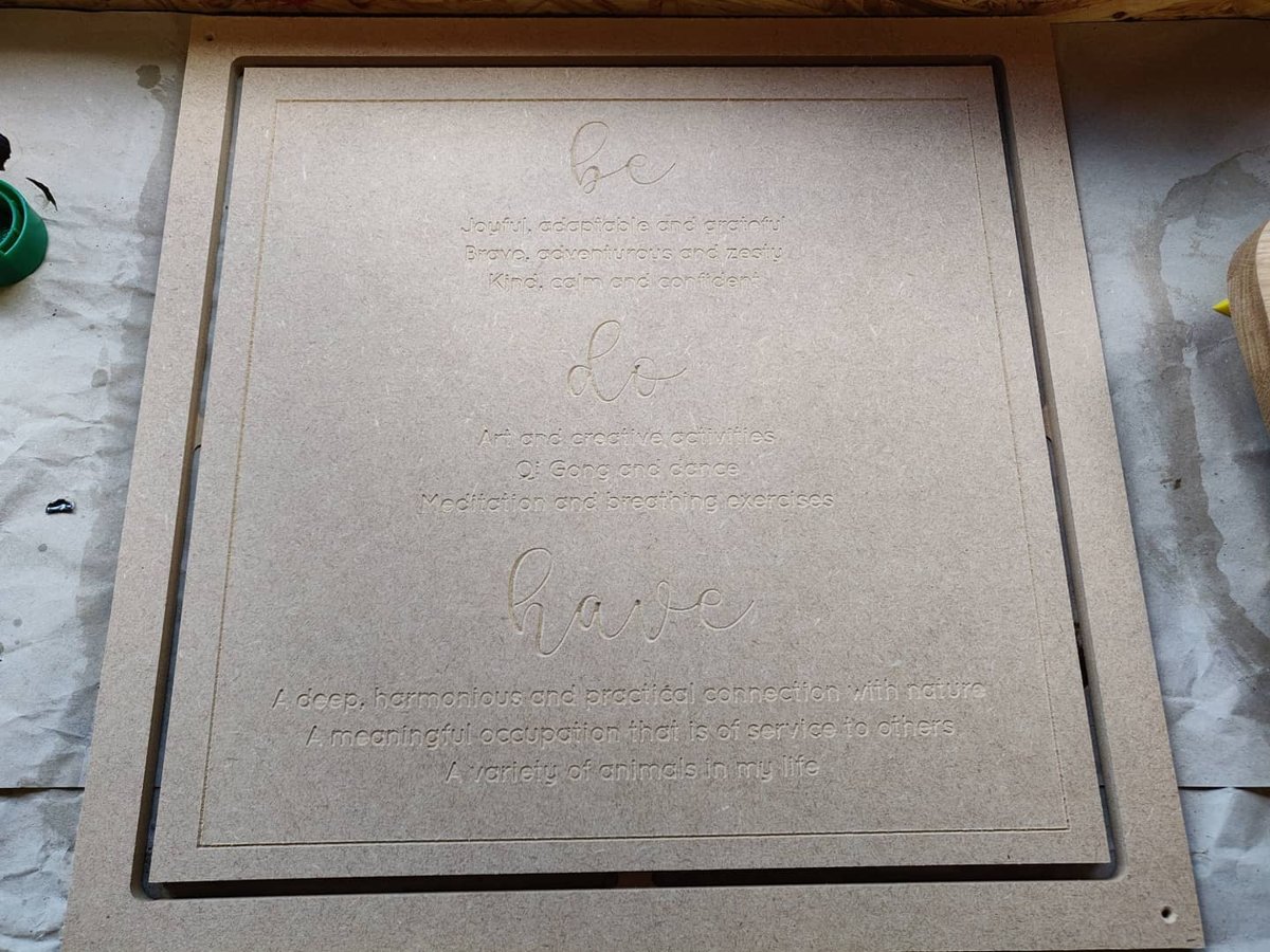 A square MDF panel carved with the words be, do and have in script, each followed by three lines of text